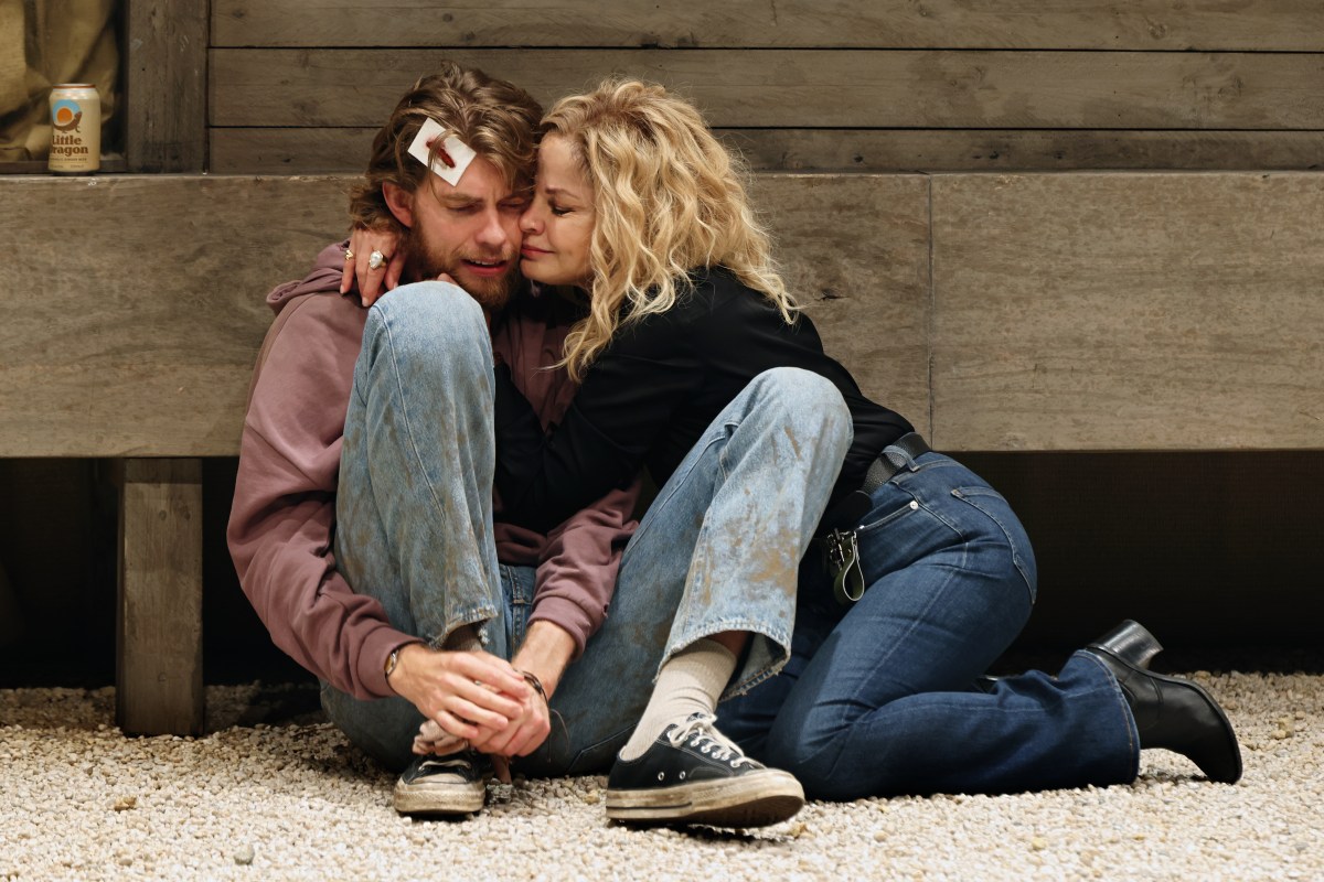 The Seagull. A young man with a bloodied bandage on his head sits with his legs drawn up to him and is embraced by an older woman in a black jumper.