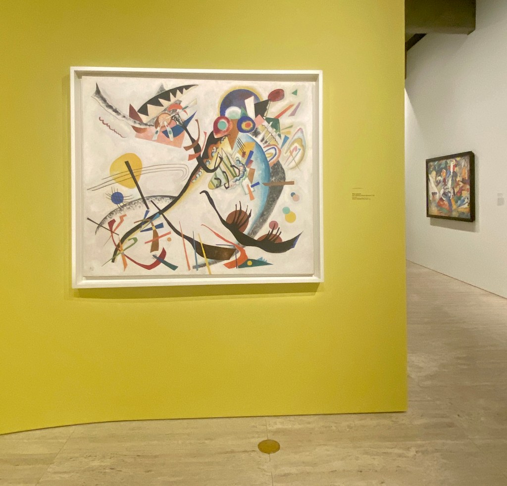Kandinsky. Abstract painting on avocado green-coloured wall iin art gallery.