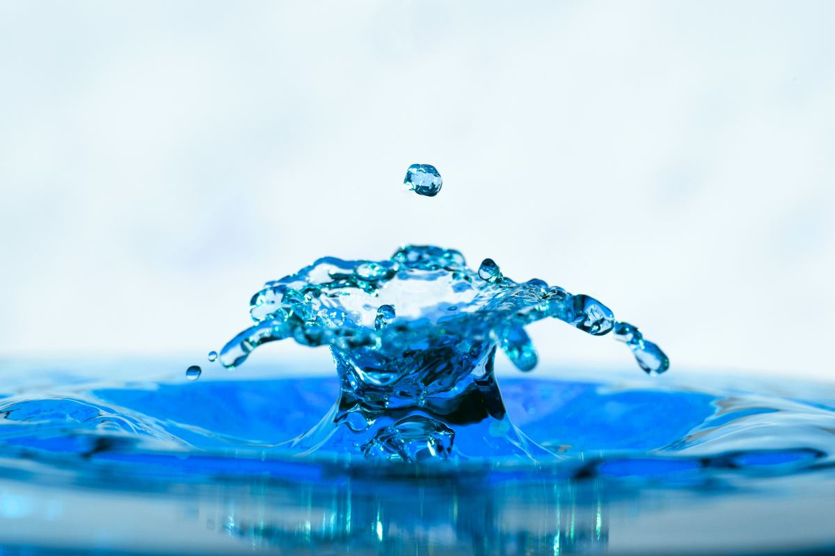 arts appointments. A close-up photo of a droplet of water creating a splash pattern in miniature.