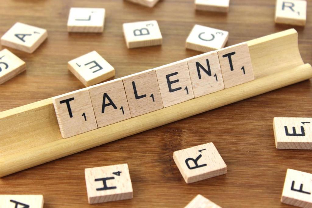 scrabble letters spelling out the word 'talent' on a wooden background.