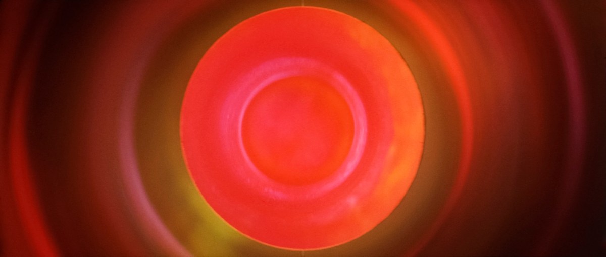 Tacita Dean. film still of a circle of red light that radiates outwards.