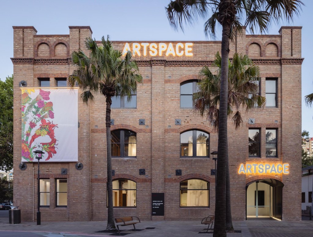 Artspace. historical building photographed at dusk with banner on facade