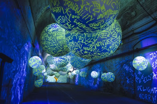 reviews. image is a blue and green light underground light installation.