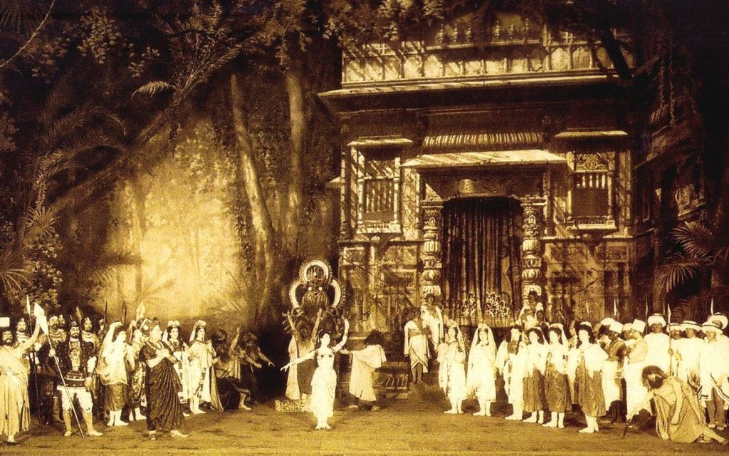 ‘La Bayadère‘ being staged at Imperial Mariinsky Theatre, 1901. Photo: Wikimedia Commons. Vintage photograph of ballet production with performers standing outside of a temple setting.