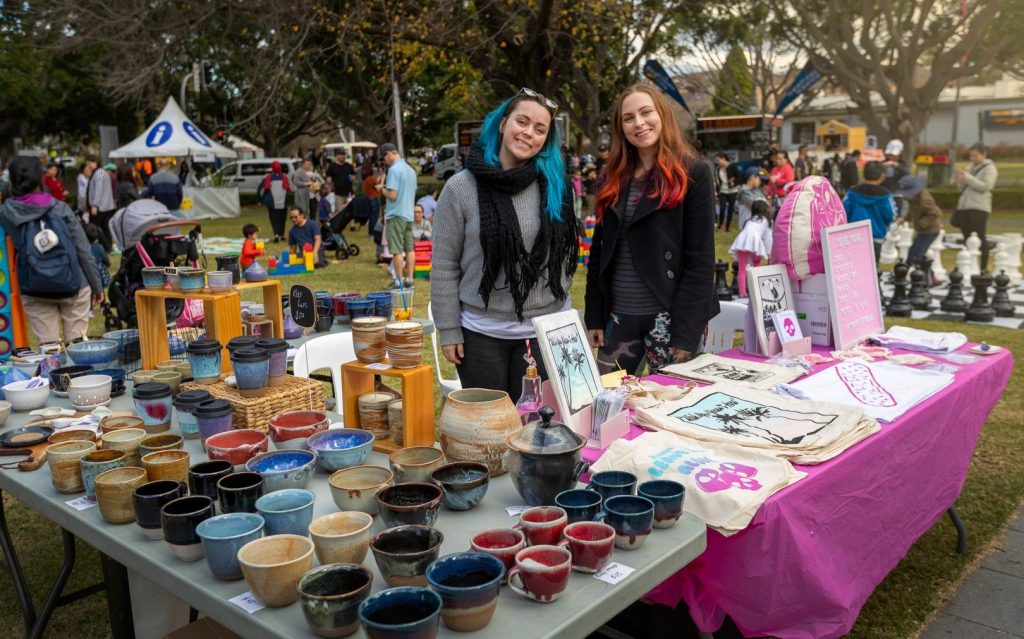 Events. Art markets at Art Nights: Culture Alive in Bankstown. Photo; Supplied. Two stallholders standing in front of tables selling their unique craft pieces in an outdoor setting.