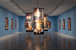 Installation view of ‘Telly Tuita: Tongpop’s Great Expectations’ at Campbelltown Arts Centre. Photo: Jodie Barker. Installation and photography works inside a spacious gallery with sky blue walls.