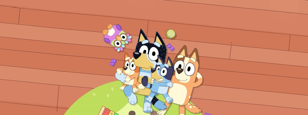 Bluey. A group of animation dogs sit on a green carpet on top of floorboards in a bunched up.