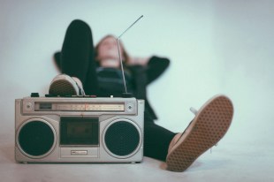 Australian music. Photo: Eric Nopanen, Unsplash. Woman lying on the ground near grey radio.