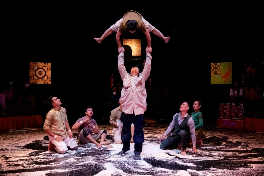 ’White Gold’ performing as part of Sydney Festival 2024. Photo: Ranuth Yun. Circus performers gather in a circle while at the centre, two performers are supporting each other while the top person does a handstand. 