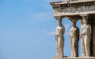 Photo: Stelios Kazazis, Unsplash. Three sculptures of goddesses on the architectural column of the Parthenon.