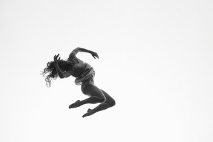 Black and white photo of a female dancer's body twisting in mid-air.