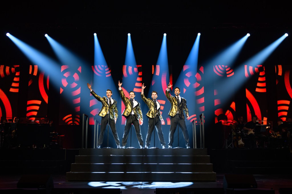 Four men on stage with showbiz lights as part of Jersey Boys Prospero Arts performance.