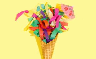 Craft hobbies using humble and nostalgic materials. Photo: Amy Shamblen, Unsplash. Colourful paper stripes shooting out of an icecream cone with a small paper umbrella at the top. The background is a pastel yellow.