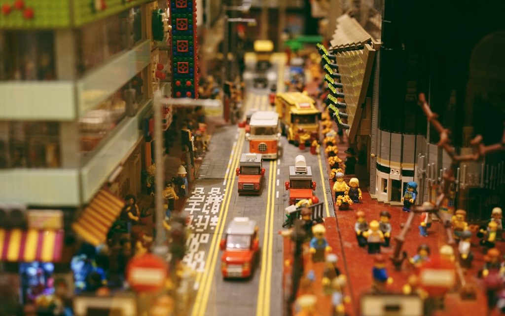 LEGO build of Hong Kong street view. Photo: Hong Lin, Unsplash. A street view built from LEGO featuring a road with different cars, and densely stacked buildings.