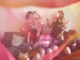 Marriage. A hazy photo of five young women on a couch with balloons and a disco ball.