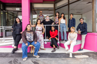 Group of artists sitting outside building.