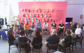 Creative Australia Leadership program workshop at Grey Art Gallery, Bandung, Indonesia 2023. Photo: Supplied. Around 20 people sitting in a circle inside a space with a bright pink wall in the background installed with colourful 3D artworks.