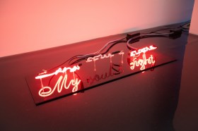 Surfacing. Image is a neon artwork placed on a gallery floor that says My... Sight with the middle word Soul not lit up.