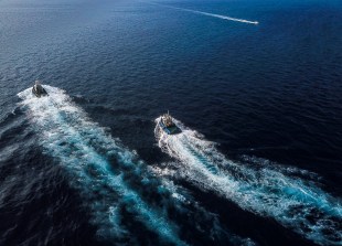 A photograph of two ships taken from high above, showing their white wakes stretching out across the blue ocean. Arts sector appointments.