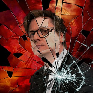 Image is a red background with a chest-up shot of a middle aged man wearing glasses, suit and tie and looking out at the camera with a neutral expression, behind a sheet of shattered glass.