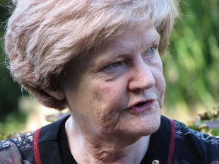 head shot of an elderly woman with blonde hair staring into distance. Jane Burns AM