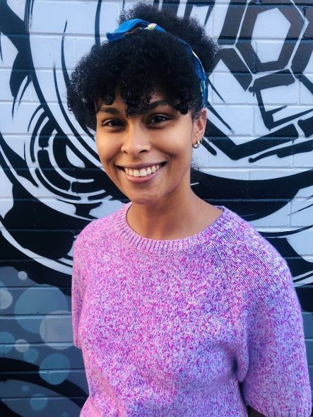 girl with pink sweater and dark hair, writer Jasmin McGaughey