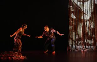 Man and woman dancing on stage with soft lighting. Asia Pacific.