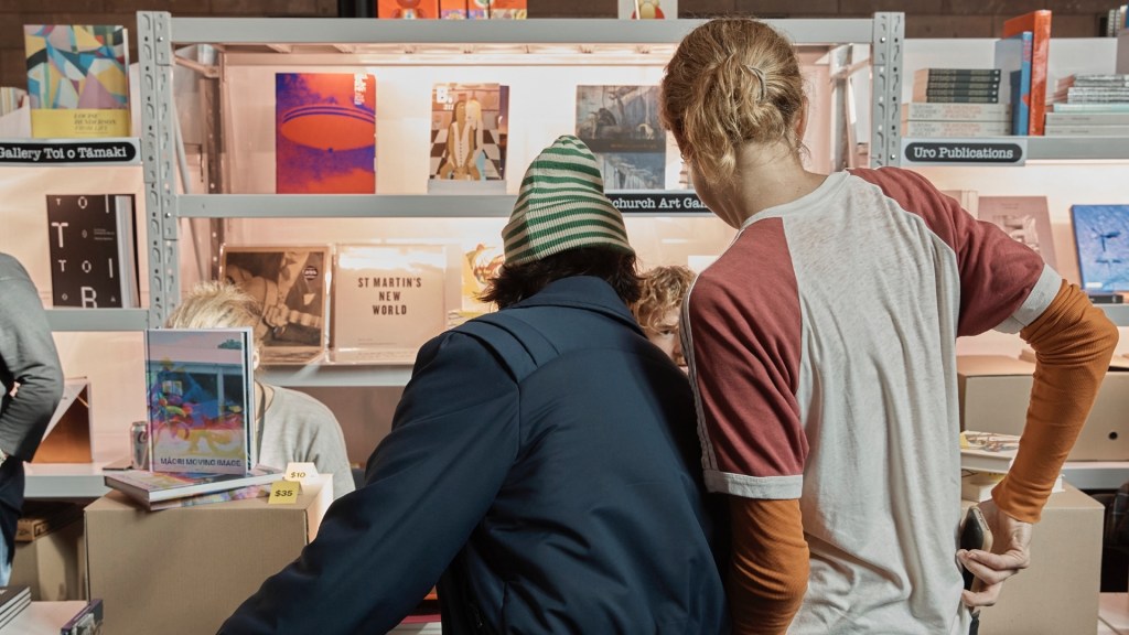 Rear view of two men looking at art books