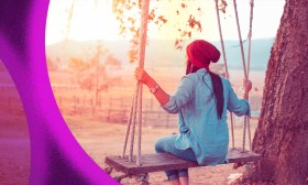 Autonomy in The Artist's Way. A woman wearing a pink hat sits on a swing facing away from the camera in the early morning light.