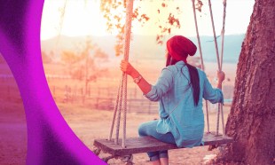 Autonomy in The Artist's Way. A woman wearing a pink hat sits on a swing facing away from the camera in the early morning light.