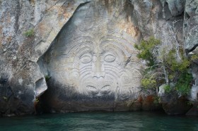 Lake Taupo. A Maori rock carving in a cliff face above water.