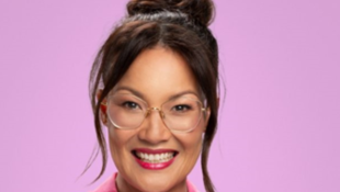 Headshot of a woman of Asian appearance with glasses, red lipstick and a bun with strands of hair down each side of her face. Lizzy Hoo.