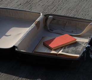 open suitcase with research books inside.