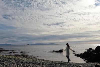 Sea, Salt and Silk. Image is an Arctic shoreline with a silhouette of a woman carrying a Perspex sheet.