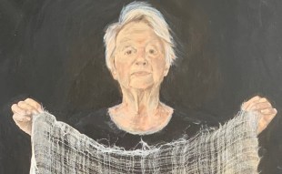 Linda Judge. Bayside Painting Prize. Image is a painting of a short grey-haired woman in a black round neck top holding up a loosely woven grey textile in front of her.