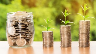 superannuation. Image is a jar full of coins, next to three piles of coins, with small sprigs growing out of the top and getting progressively higher.