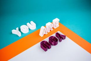 a brightly coloured photograph of #D block lettering that spells: "You are" in white letters, and "You" in dark red letters.