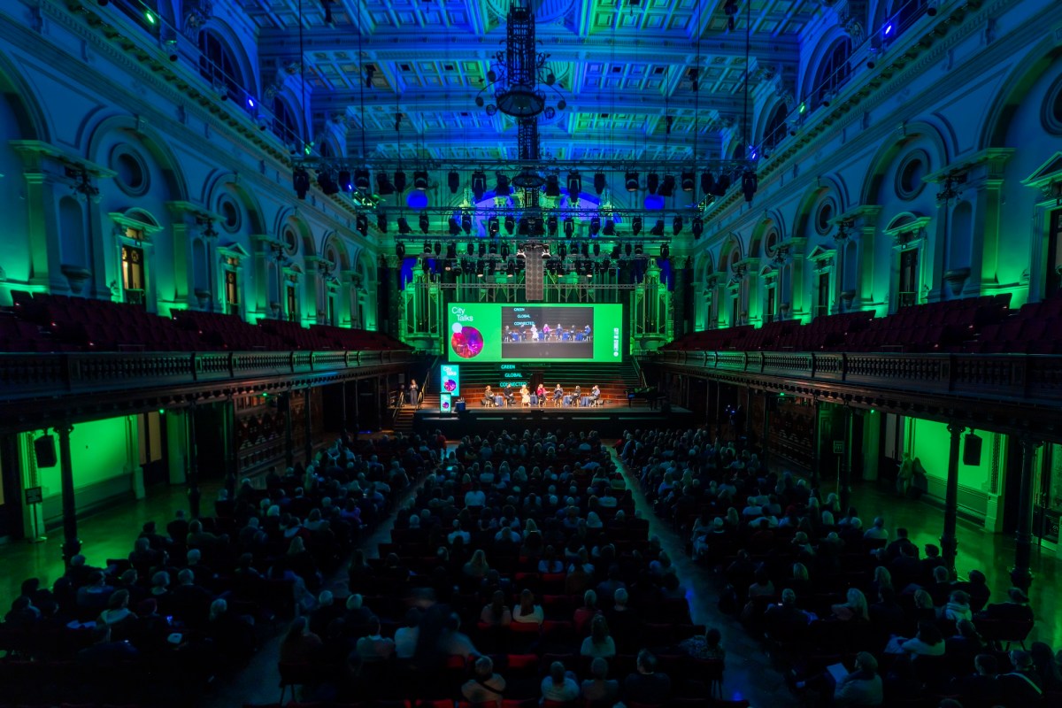 A town hall event will audience and colourful lighting in room. City of Sydney.