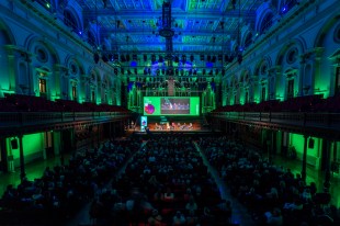 A town hall event will audience and colourful lighting in room. City of Sydney.