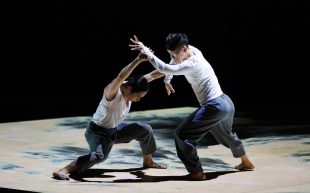 Hong Kong Dance Company's 'Convergence' touring to Sydney. Photo: Supplied. Two dancers engaged in martial arts movements on a stage. The stage floor seems to be a digital screen with black and white swirls.