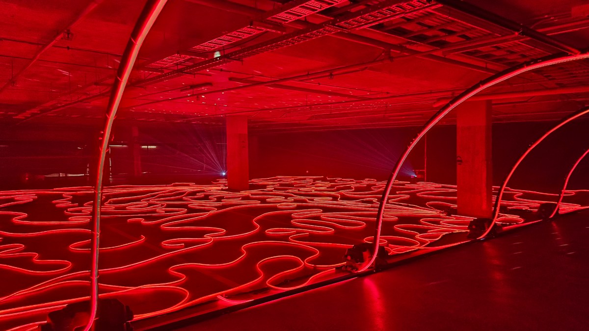 ‘Firelight Labyrinth’. Photo: ArtsHub. Red LED light tubes snaking through the underground carpark, illuminating the entire space.