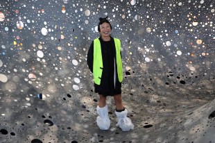 woman in hi-vis vest standing inside sculpture. Lindy Lee