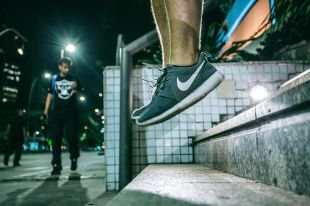 Close-up of a person's feet as they exercise on stairs at night by jumping into their air.