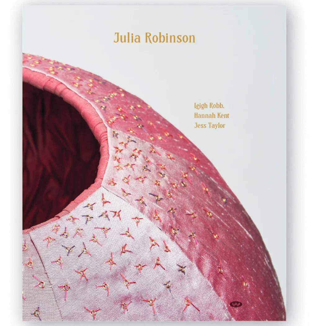 White book cover with detail of pink fabric sculpture