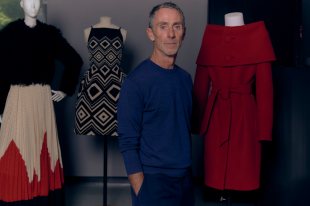 Man in blue jumper standing with fashion on manequins, Martin Grant.