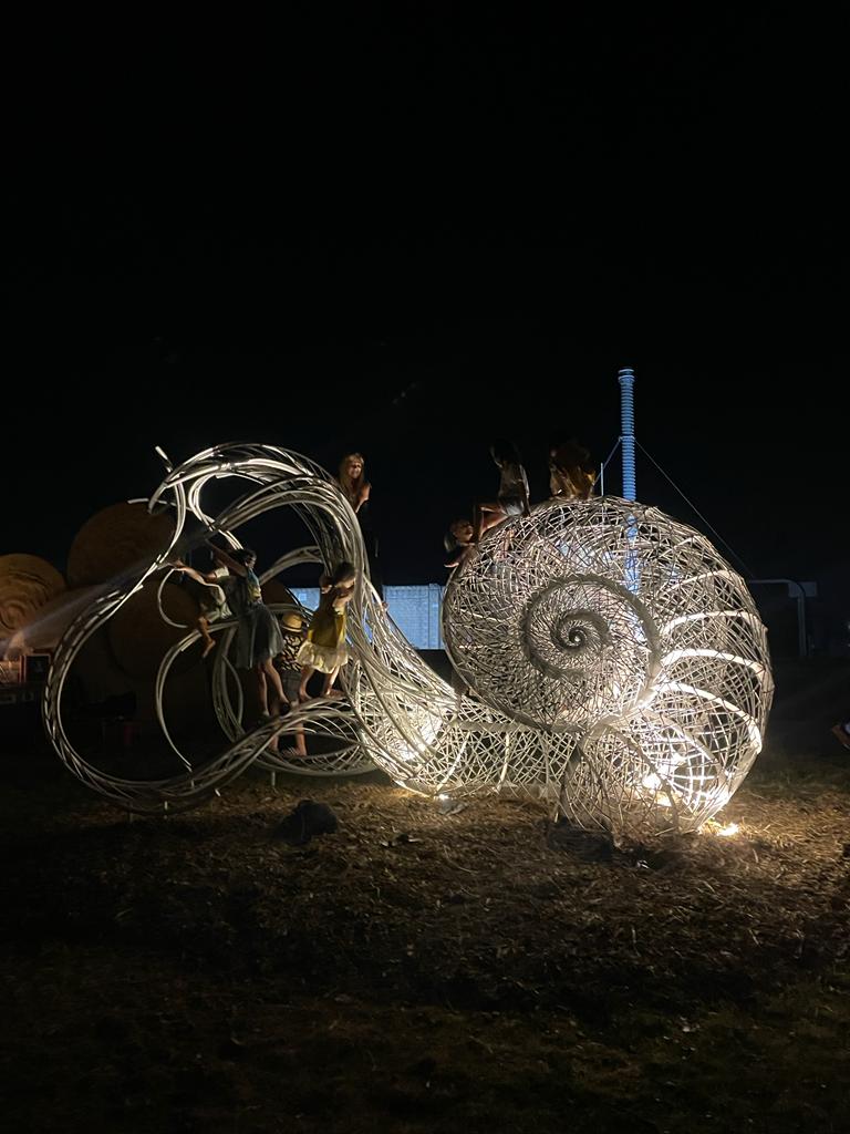 Steel sculpture of a snail, shell like creation at night