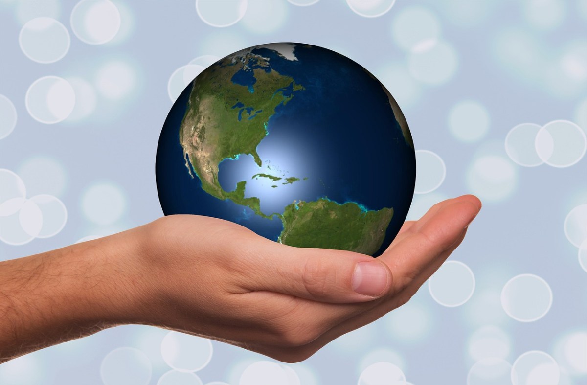 A hand cradling a small globe. Poetry Month