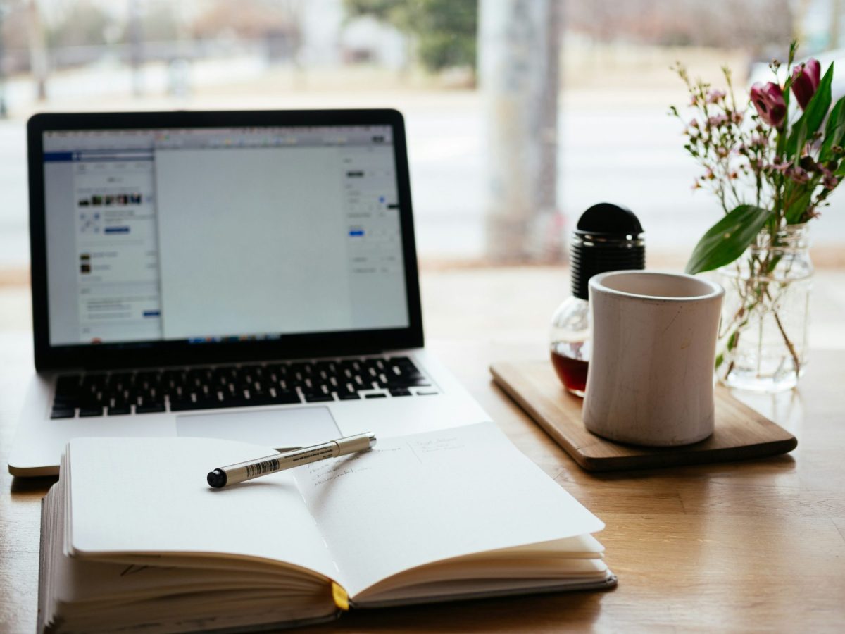 Australia has many opportunities for playwrights. This photo is of a simple office desk, with a computer, open notepad, and tea cup.