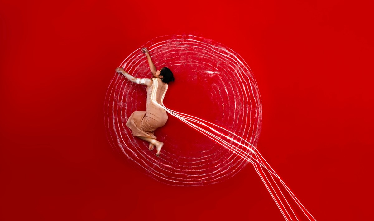 woman's body in performance against red background. APT