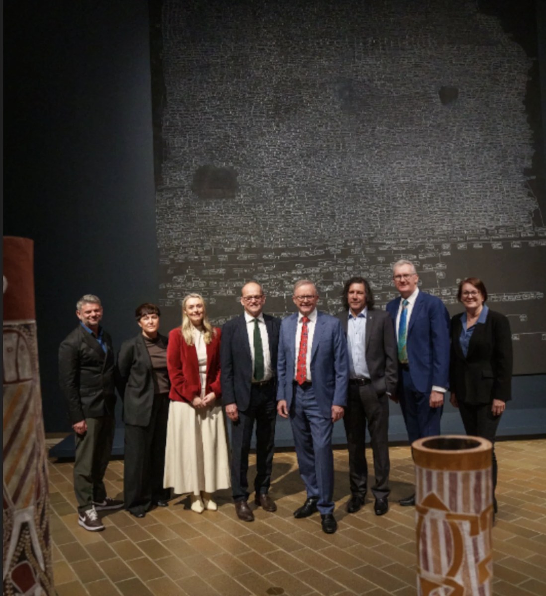 Group of people standing in front of artwork by Archie Moore. kith and kin